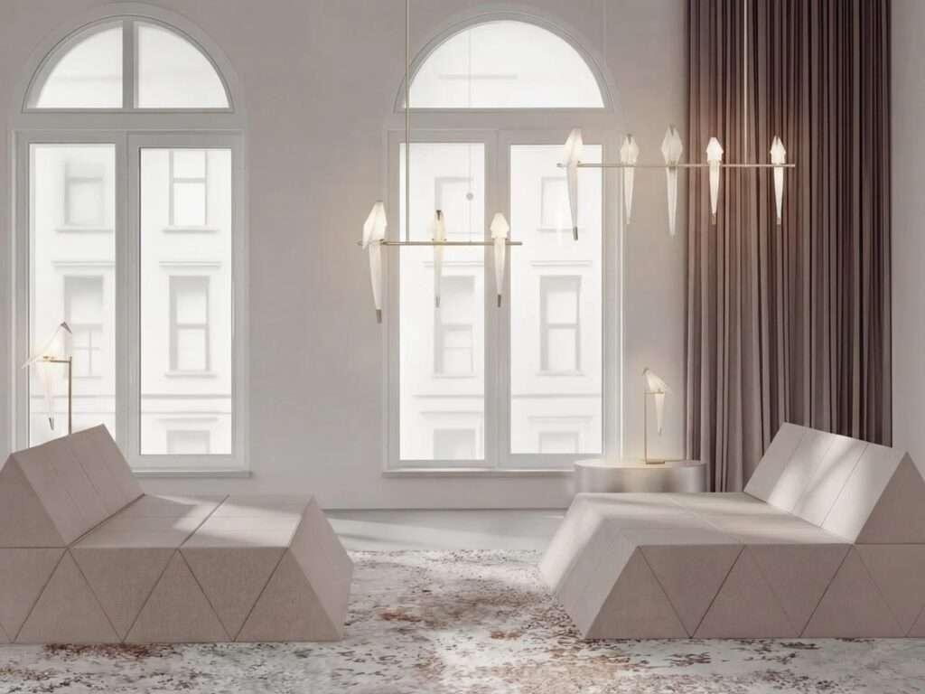 Symmetrical minimalist living space featuring low, geometric modular beige lounges beneath a modern chandelier shaped like abstract white birds.