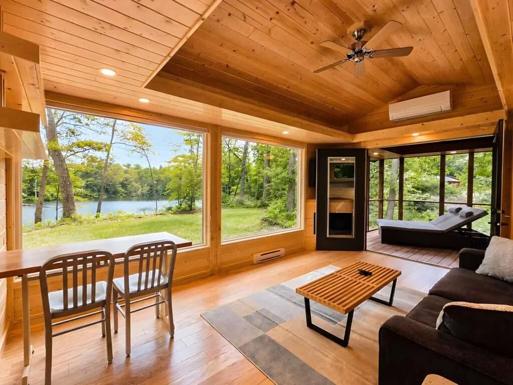 Bright living room area with high-efficiency layout showcasing a mini-split air conditioner, ceiling fan, sofa, dining table, and direct access to a screened outdoor porch.
