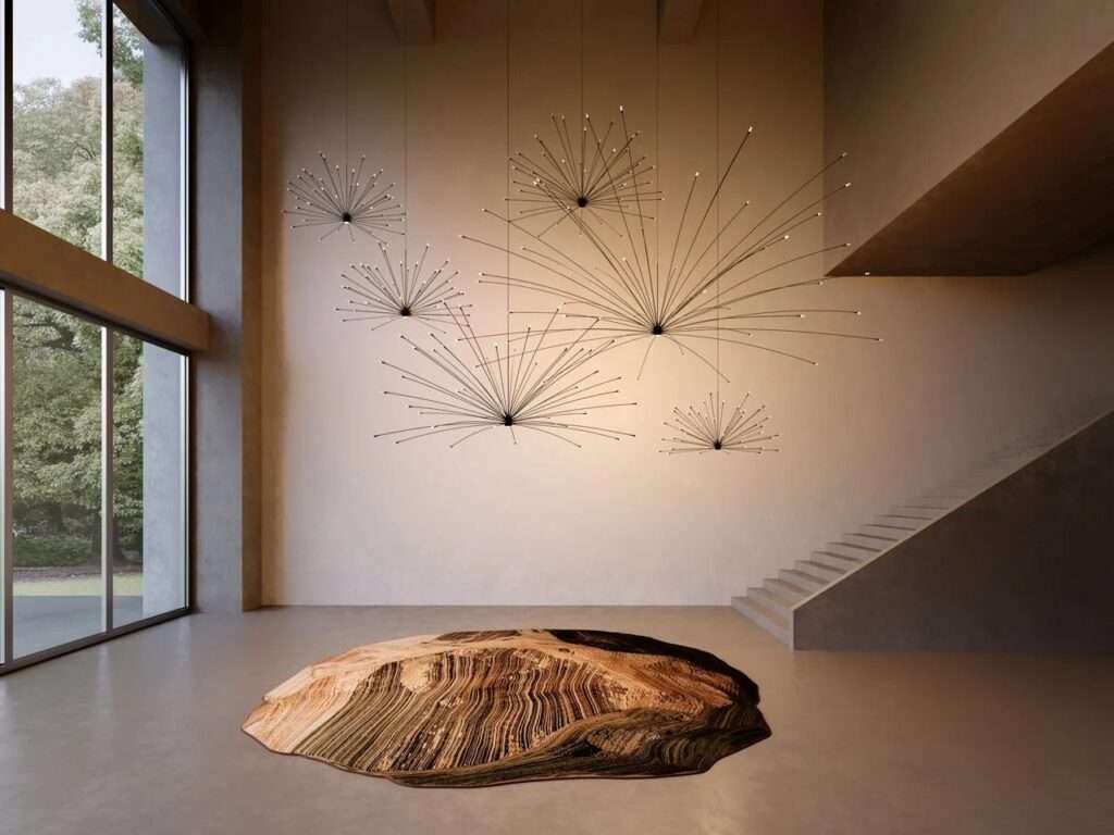 Double-height modern interior with a collection of fine-lined exploding starburst pendant lights suspended above an organic, topographic-patterned floor rug.