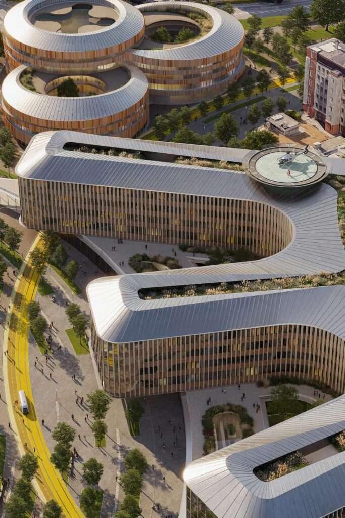 Aerial view of the Brescia hospital campus showing the serpentine main wings, cylindrical pediatric buildings, and a yellow transit loop track.