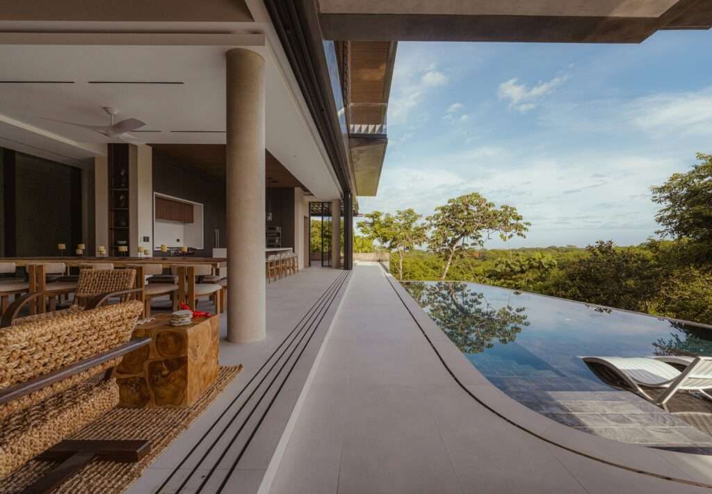 Low-angle interior lounge view looking out to a reflecting pool and natural landscape at KUL Nosara.