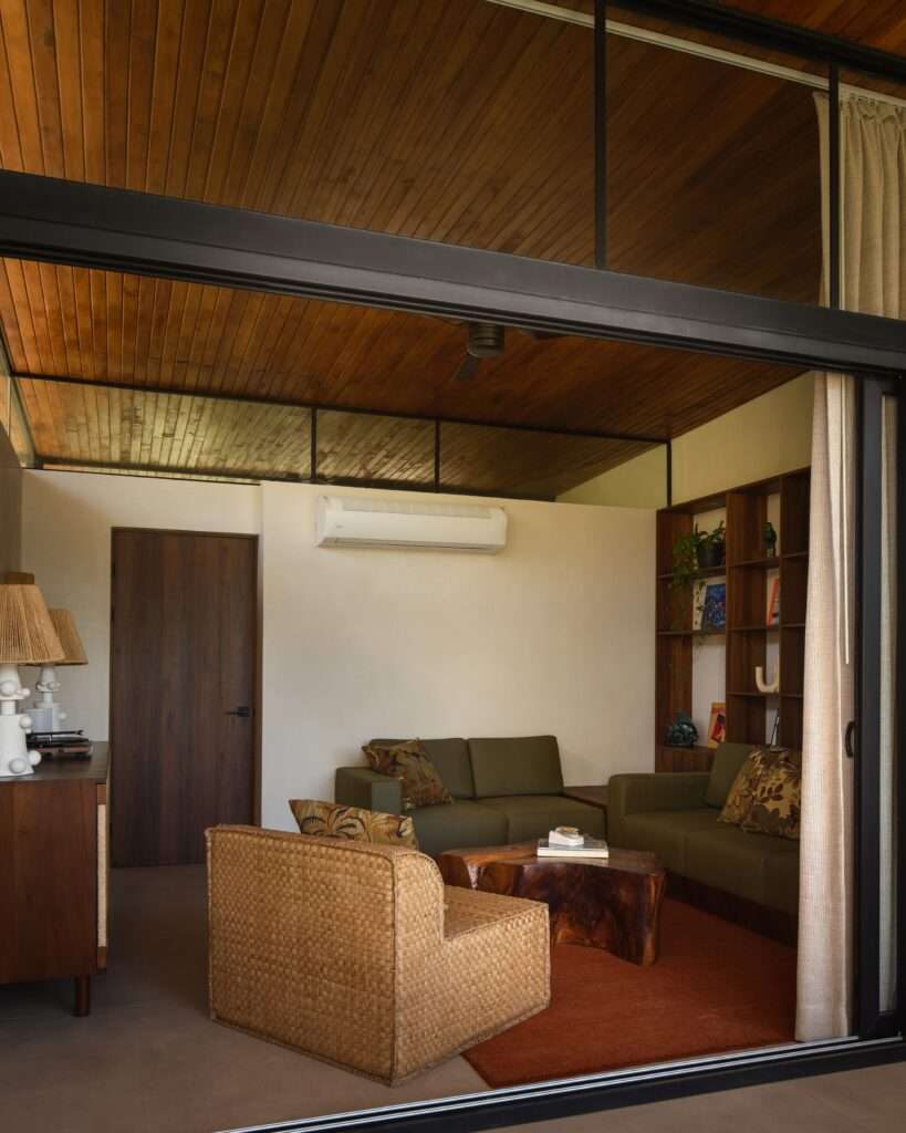 Dusk photography of El Molino complex showcasing warm interior lighting filtering through wooden louvers into the central gravel courtyard under a deep blue sky.