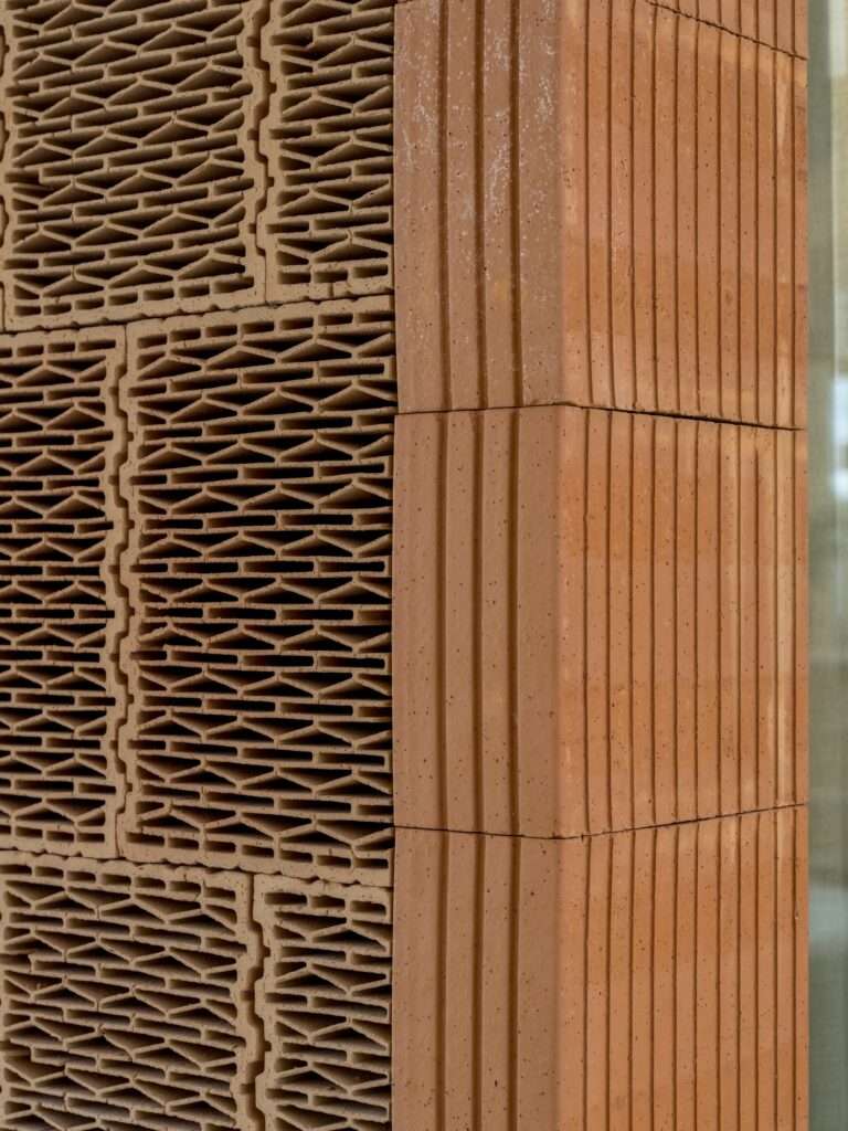 Close-up of low-carbon acoustic clay tiles and porous clay block walls inside Dymak HQ.