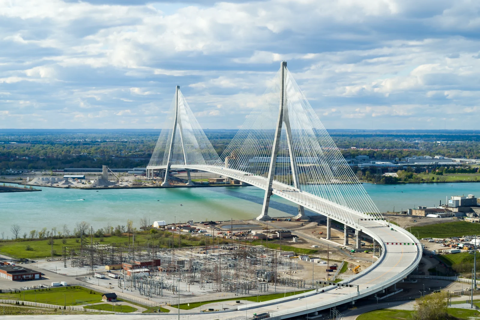 A six lane cable stayed bridge stretching across the river connecting highway infrastructure on both sides.