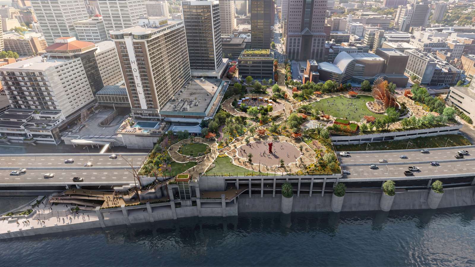 Aerial view of a urban waterfront park built over a highway adjacent to high-rise buildings.