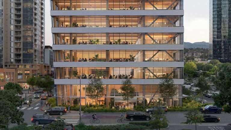 Glazed lower floors of a modern mass-timber office tower along an urban street at dusk.