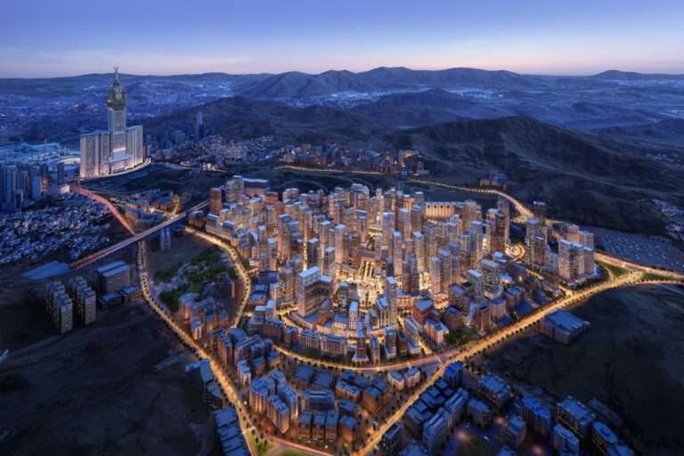 Aerial night view of high-rise urban master plan with illuminated streets near Abraj Al Bait in Makkah.