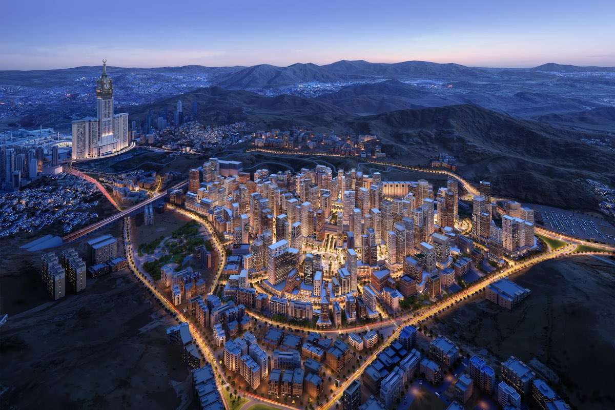 Aerial night view of high-rise urban master plan with illuminated streets near Abraj Al Bait in Makkah.