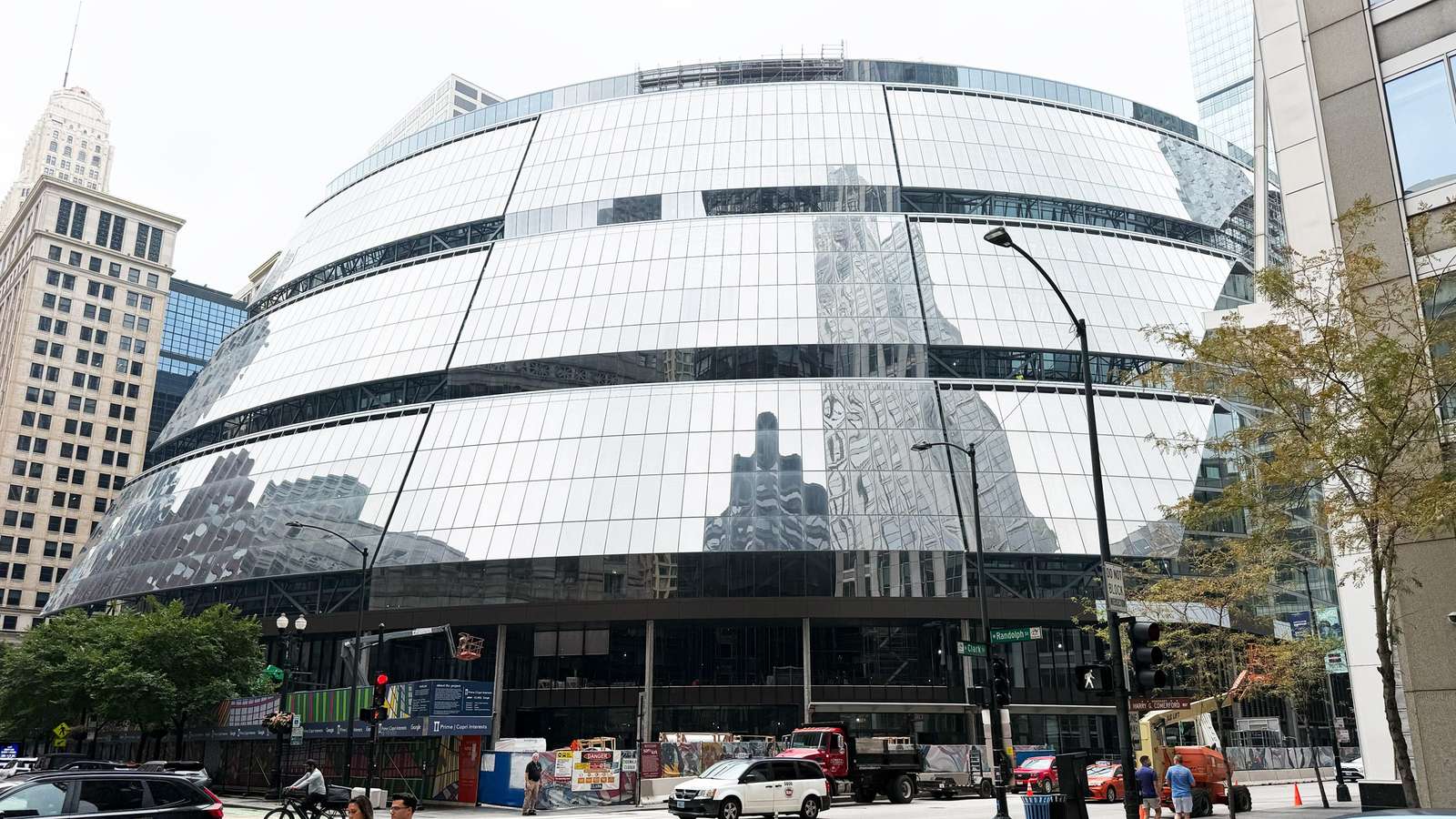 Sloped, reflective glass curtain wall on the curved facade of the Thompson Center undergoing renovation.