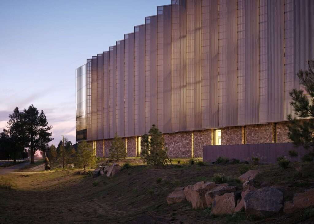 Close-up of a library facade with vertical metal fins set above a stone wall.