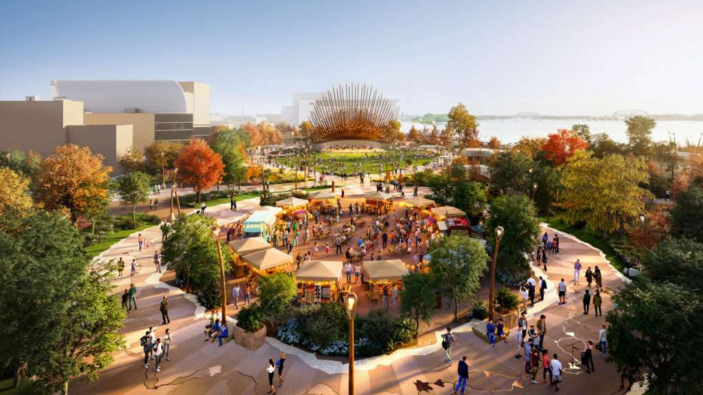 A plaza with circular paving patterns, market stalls, and light posts near a performance pavilion.