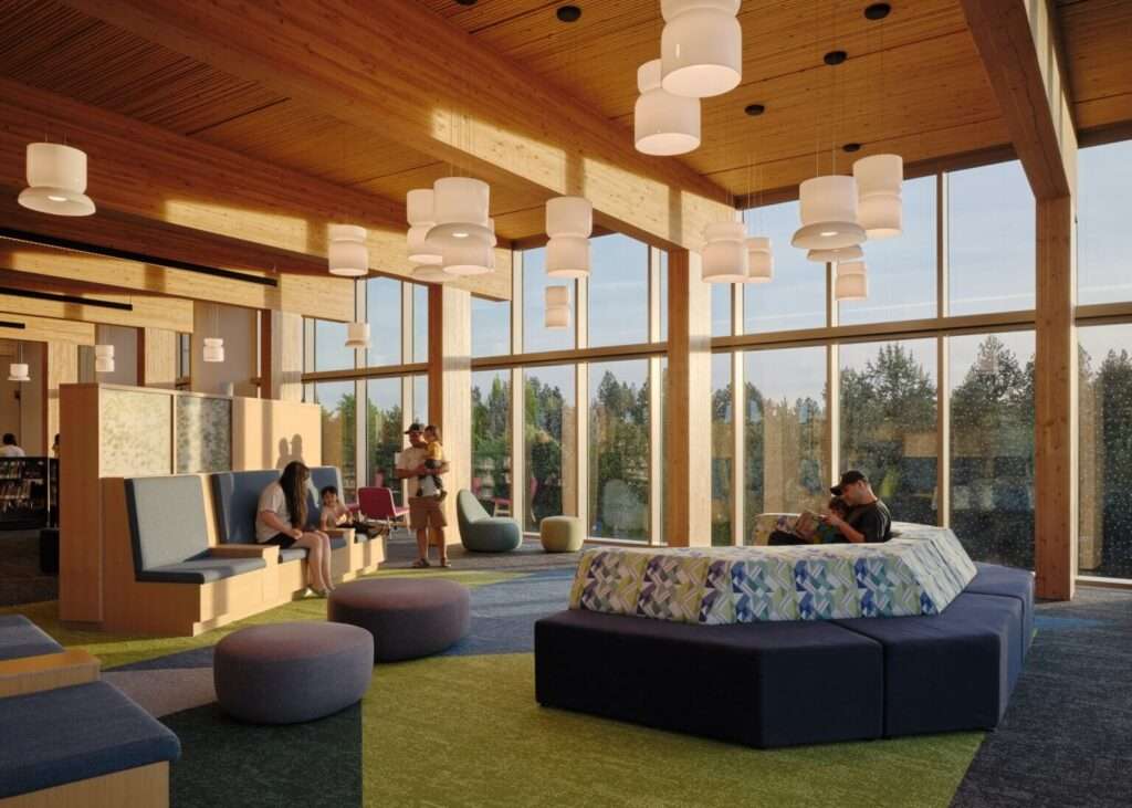 Interior room featuring mass timber columns, low modular seating, and large windows looking outdoors.
