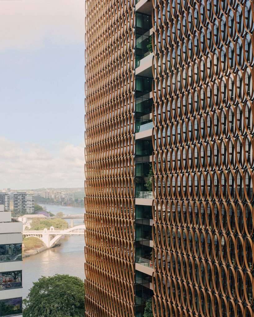 Angled view looking up at the repeating elliptical brise-soleil system of the tower facade