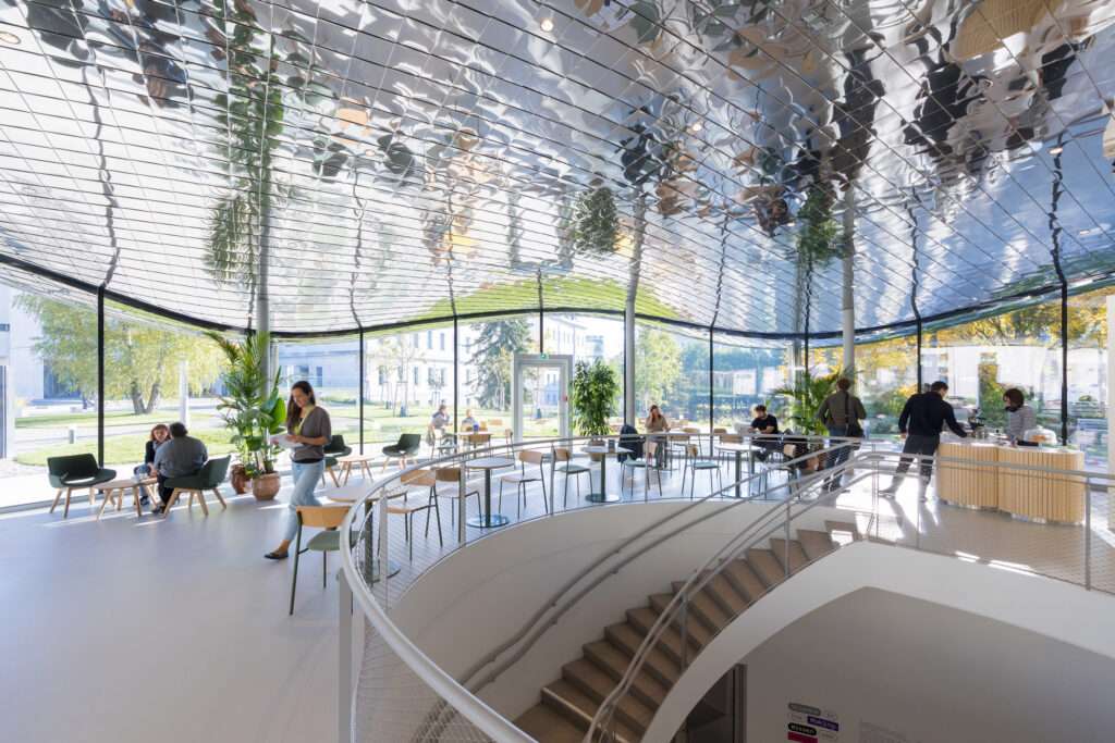 Open glass-walled interior featuring a mirrored tile ceiling and a central circular stair opening