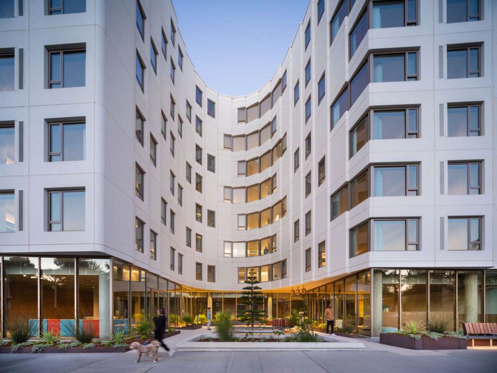 Curved interior courtyard facade with extensive glazed ground floor enclosure and upper level fenestration.