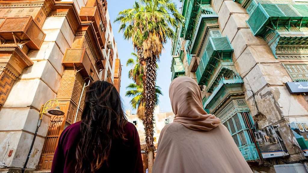 منظر من زاوية منخفضة نحو الأعلى بين مبانٍ تاريخية تضم رواشين خشبية مزخرفة.