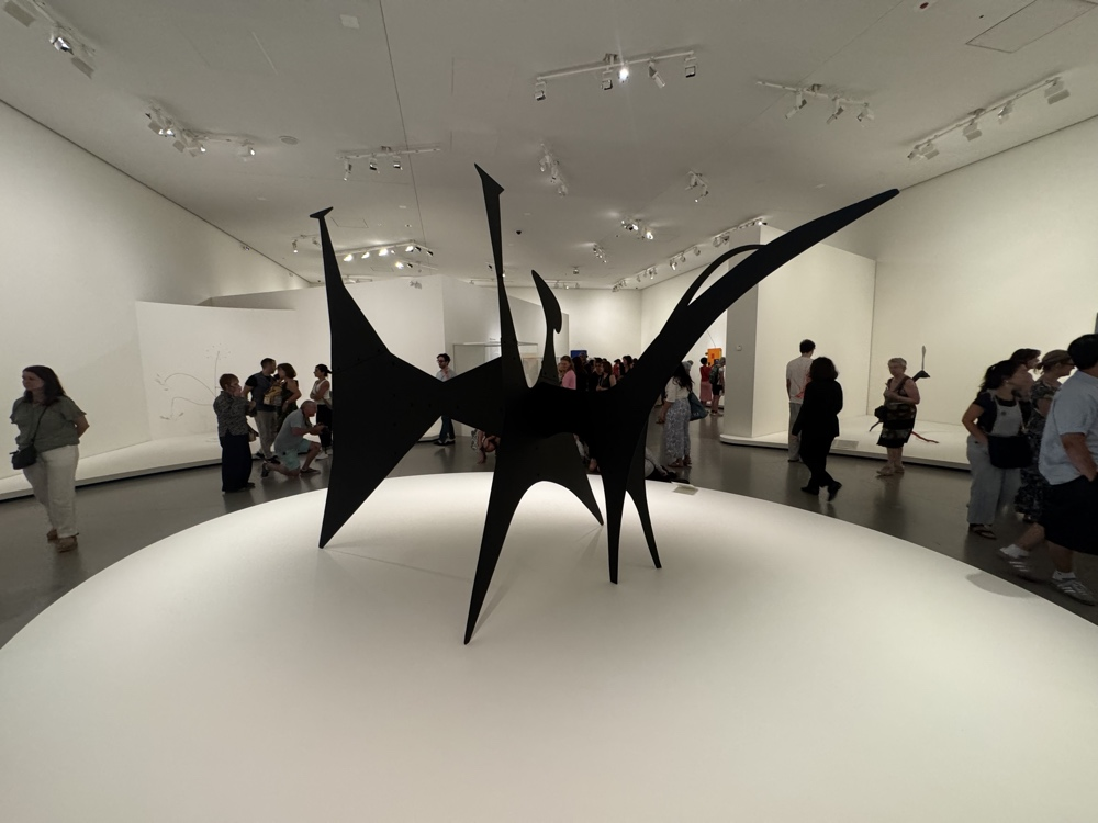 A monumental black Alexander Calder stabile displayed inside Fondation Louis Vuitton.