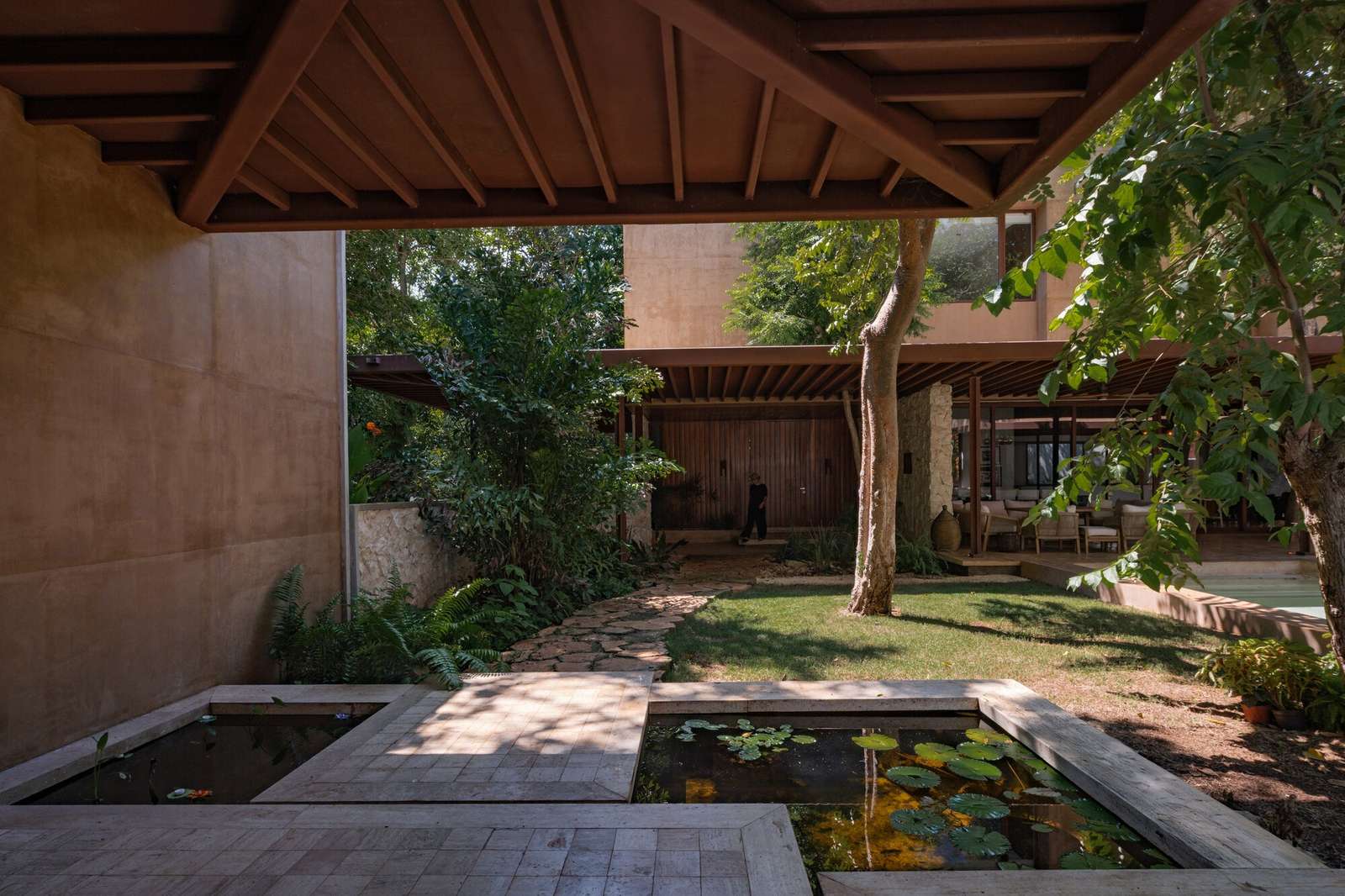 Water feature basin with lily pads and stone pathway in the courtyard of Casa Sudzal.