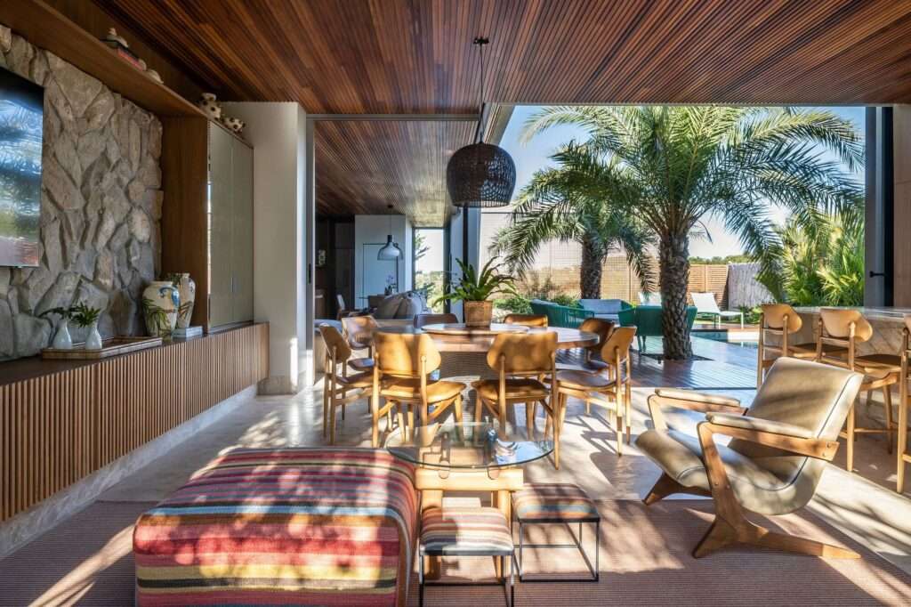 Modern living area with mid-century styled furniture, textured rug, and direct visual access to the outdoor palm courtyard.