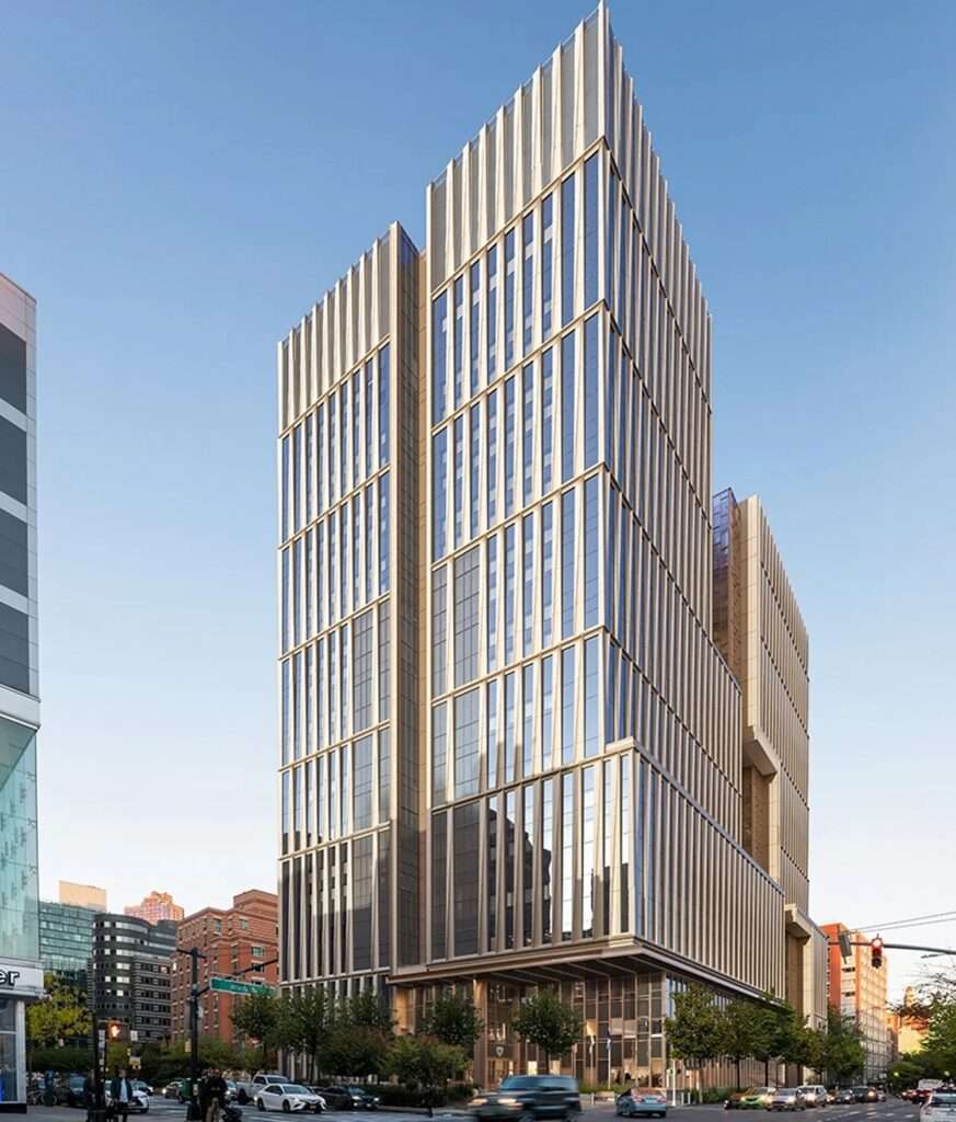 Exterior view of the Manhattan Detention Center skyscraper showing a split tower massing with a double-skin facade.