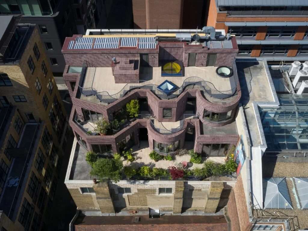 Aerial top-down view of Smart's Place rooftop extension in Covent Garden showing dark purple brickwork, circular skylights, and terraced levels.