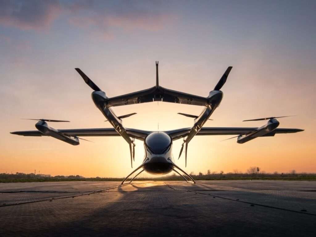 Front view silhouette of the AutoFlight eVTOL aircraft on a landing pad at sunset.