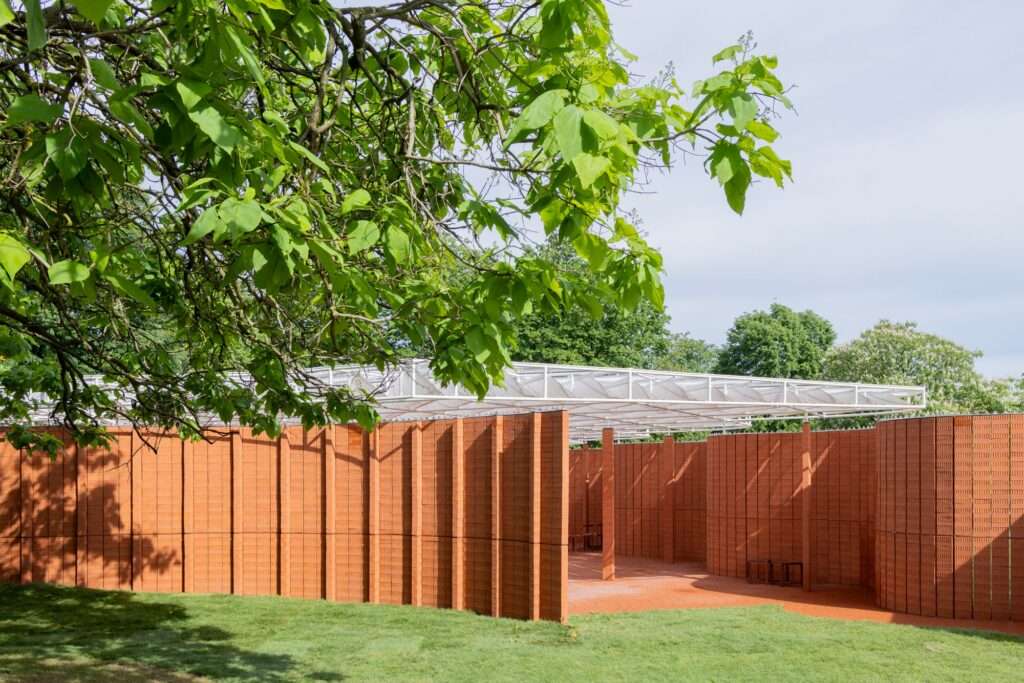 Close-up view along the curved red brick wall and translucent roof Serpentine Pavilion