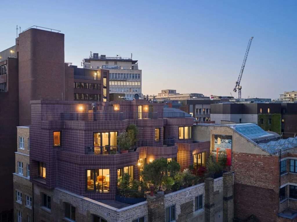 Smart's Place two-storey rooftop extension illuminated at dusk against the surrounding London skyline.