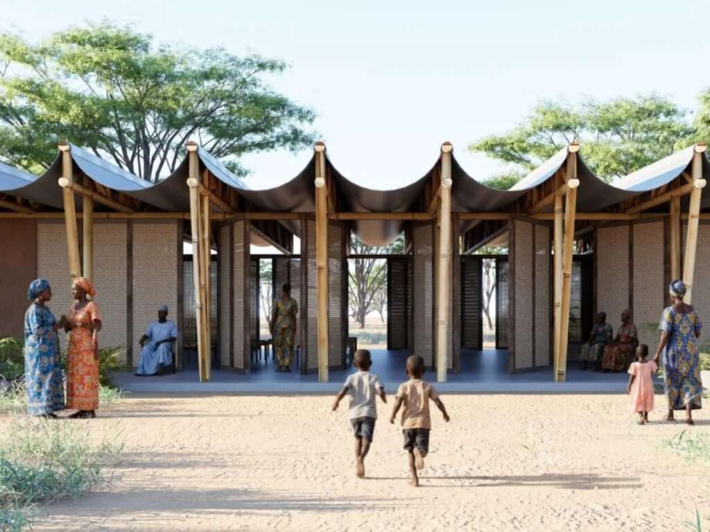 Front view of a community center pavilion in Senegal showing tall bamboo columns, modular screens, and an inverted wave-like roof structure.
