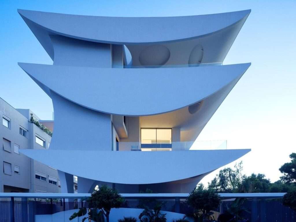 Symmetrical view of Rive en Hospense modern building facade featuring petal-like white balcony volumes and glass balustrades.
