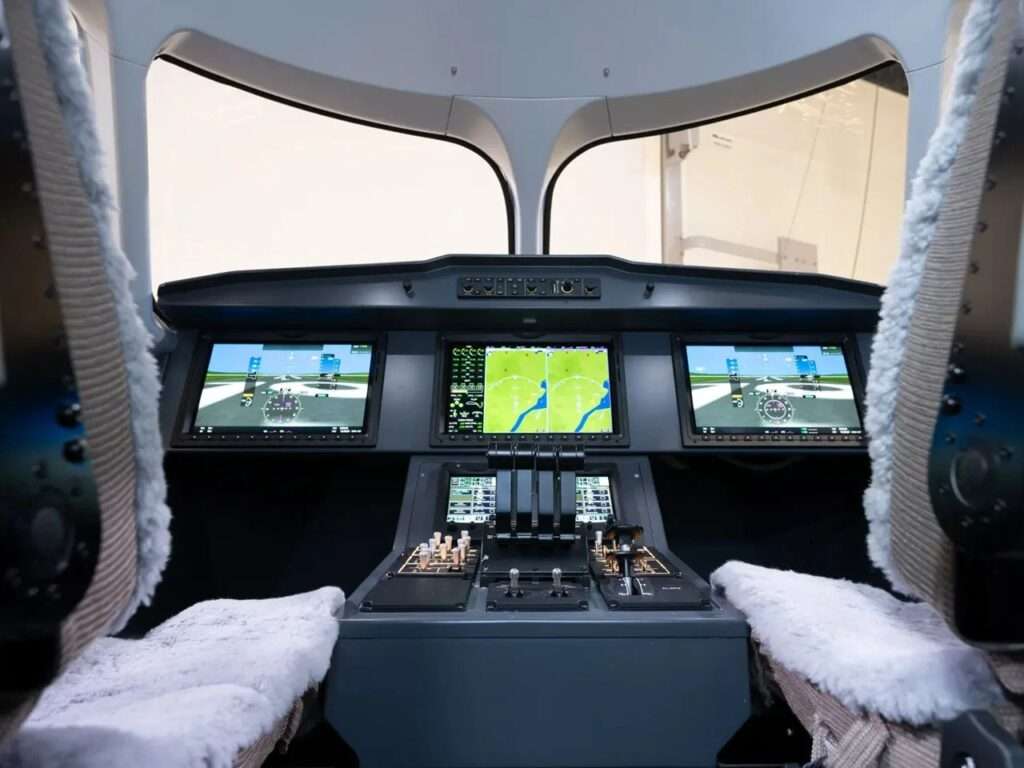 Modern glass cockpit flight deck of the Heart X1 aircraft with large digital avionics display screens.