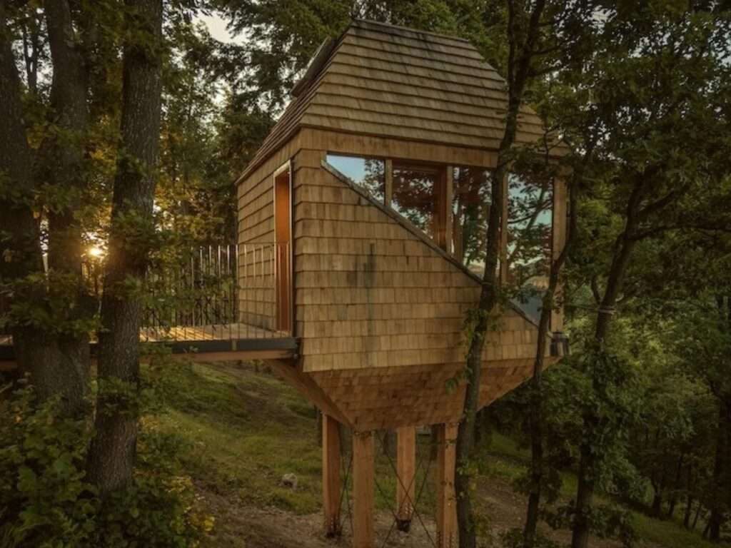 TreeBOX wooden cabin profile showing entry bridge and side window opening during sunset.