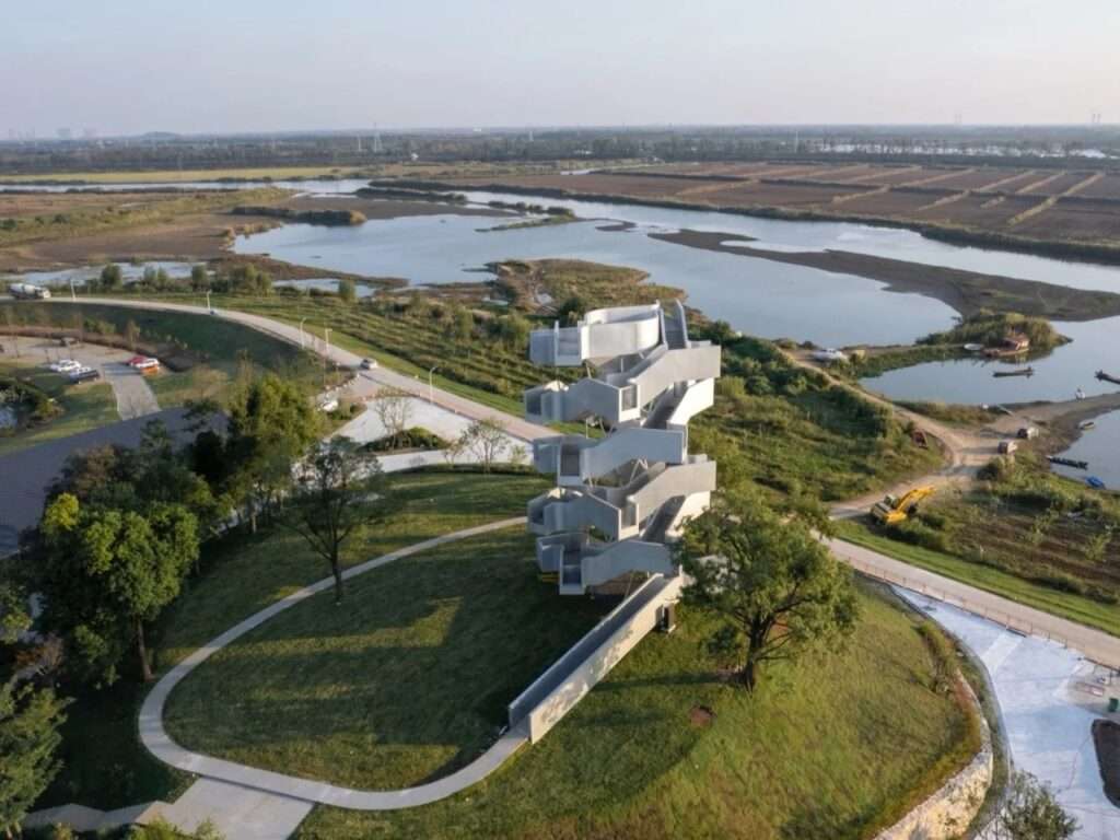 High aerial shot of Qinghu bird observation tower overlooking wetlands, rivers, and agricultural fields.