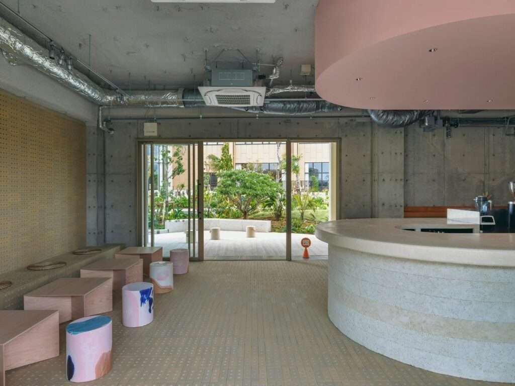 Open interior view of SR Ice Cream shop looking out through large glass sliding doors onto a lush outdoor garden.