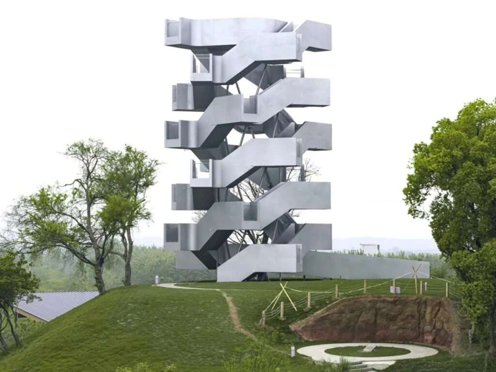 Front view of Qinghu Migratory Bird Observation Tower standing on a green mound above a circular landscaped area.