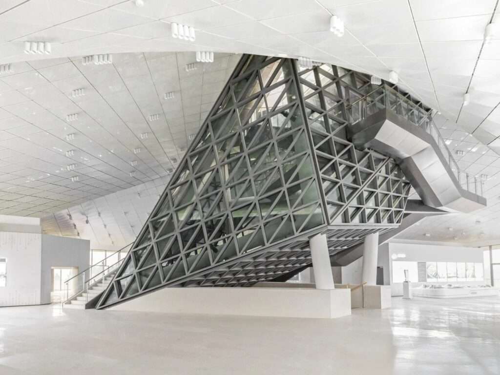 Modern interior atrium of Chengdu Pavilion featuring a geometric steel truss structure and bright white ceiling.