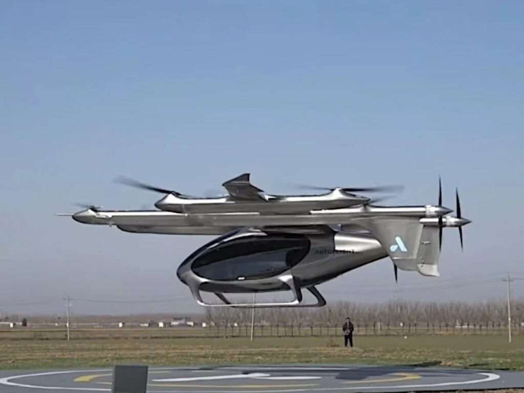 Close-up profile view of the AutoFlight eVTOL aircraft hovering above a helipad.