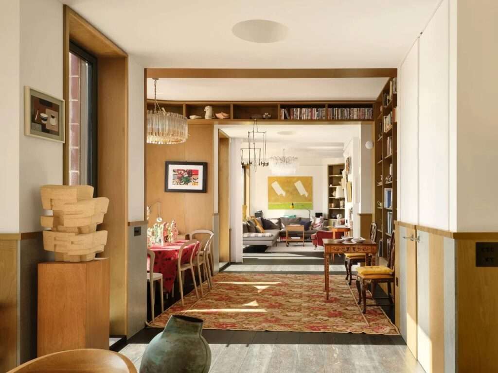 Interior view showing an enfilade spatial sequence looking through the dining room, library, and living area without interior doors.