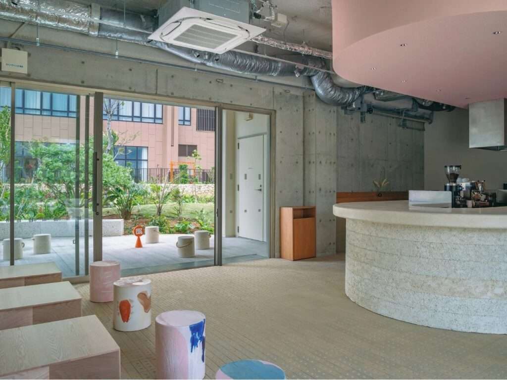 Side view of SR Ice Cream interior showing seating area along glass facade and central lime plaster counter.