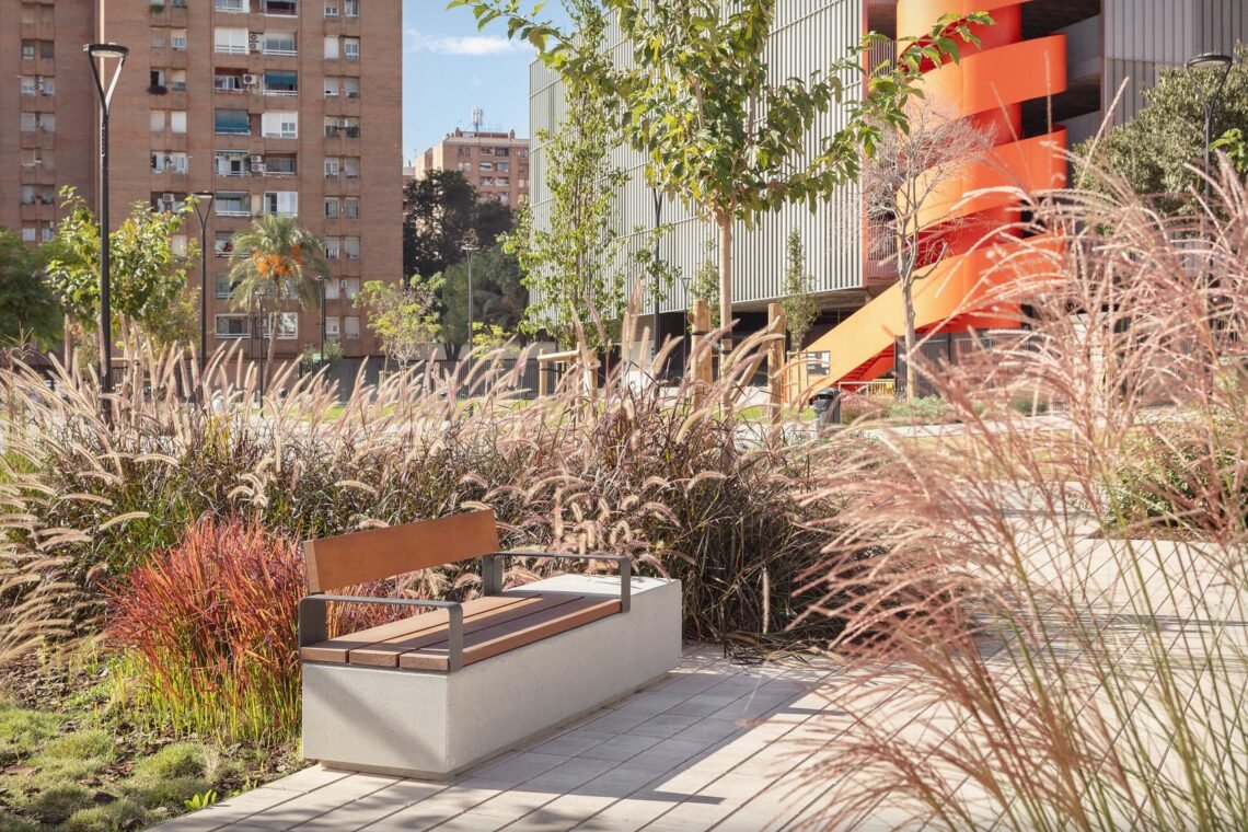Bench set beside ornamental grasses.