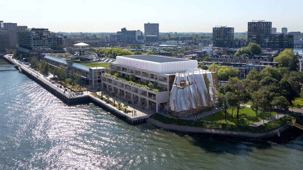 Aerial view showing a transformed art deco warehouse with a rippled glass extension along the waterfront quay