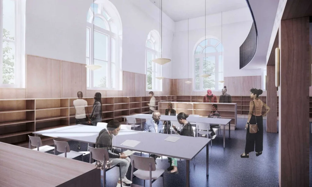 Double-height interior reading room with large arched windows, wooden millwork, and reading tables