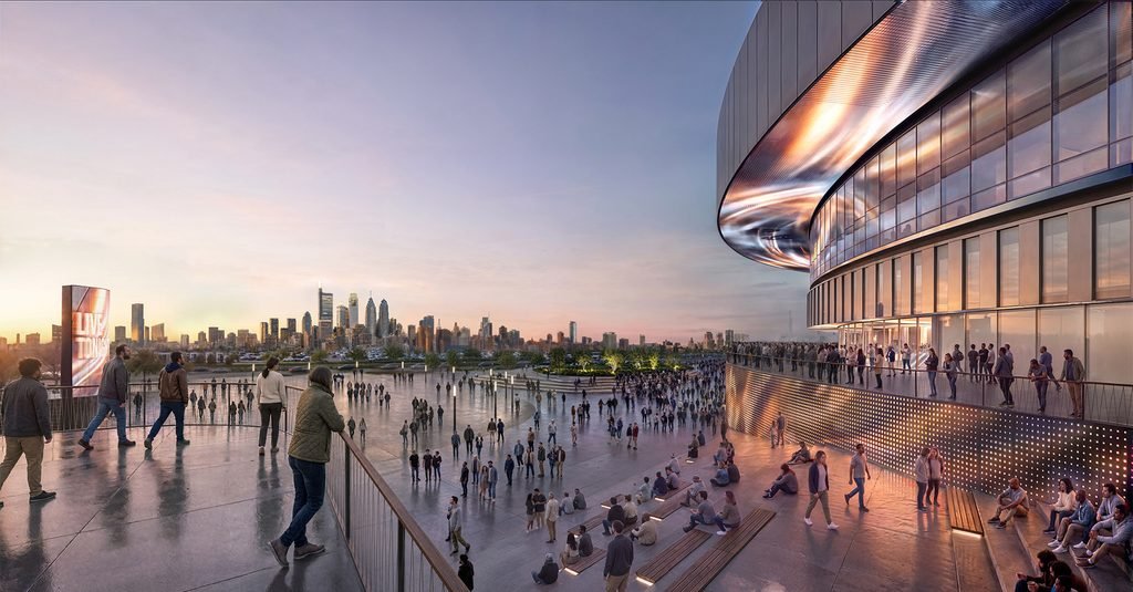People gather on elevated walkway balcony overlooking plaza and distant city skyline