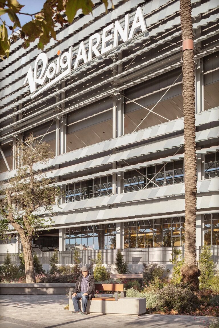 Arena entrance beside trees and planted edges.