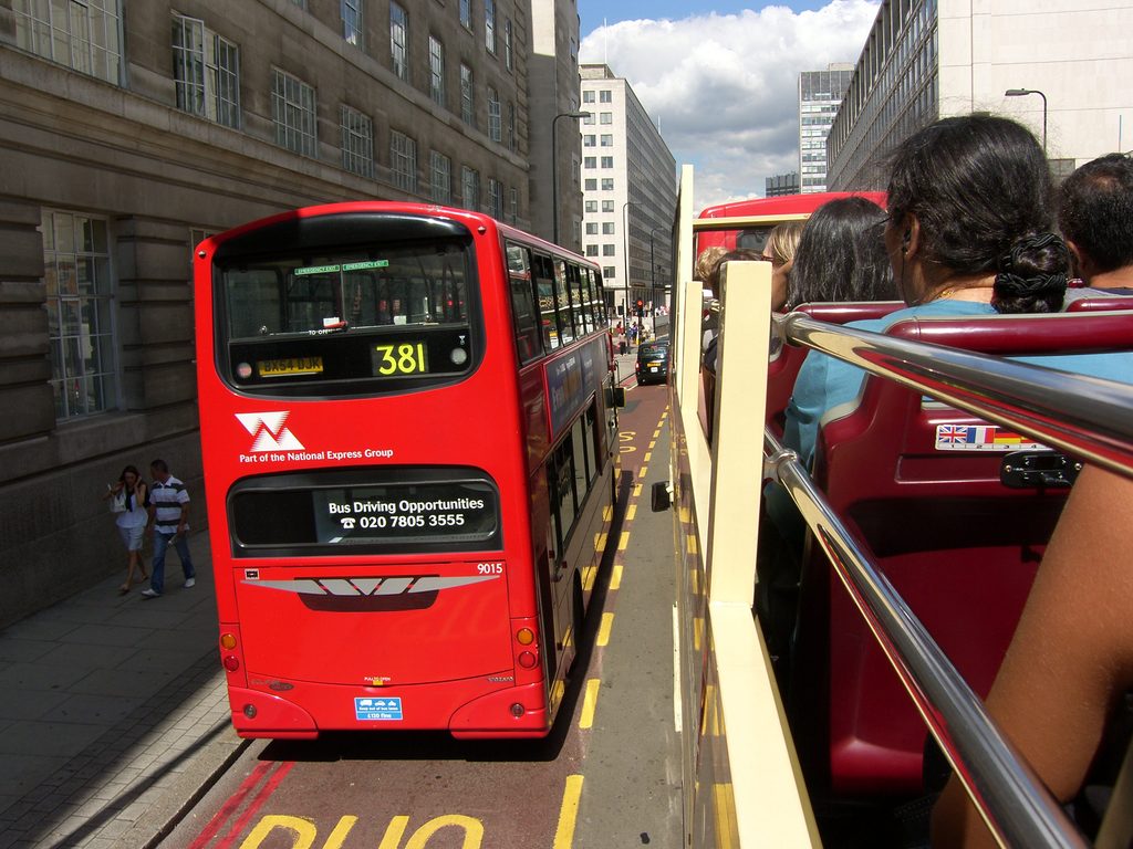 A slightly blurred view of an older model red double-decker bus on route 381, taken from the top deck of another bus, with a grey banner reading "SAMSUNG DIGITAL CAMERA" at the bottom.