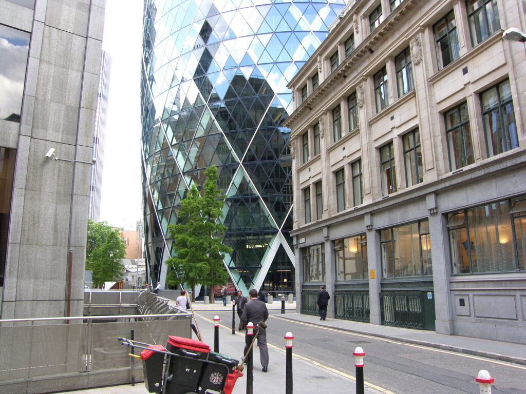 30 St Mary Axe, known as The Gherkin, rising behind traditional buildings on a London street