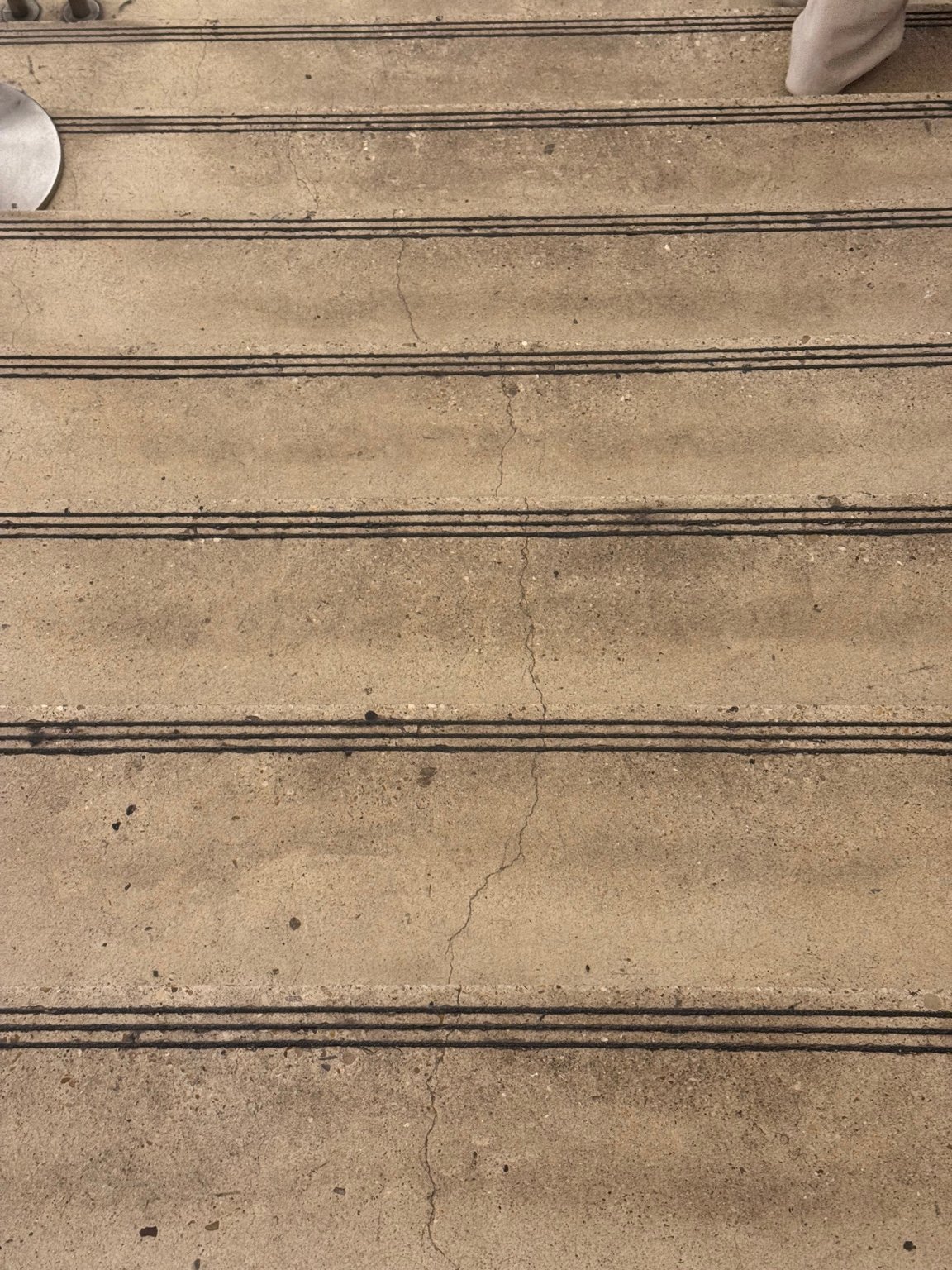 Stair wear and surface cracking at the Louvre, photographed as part of an architectural observation.