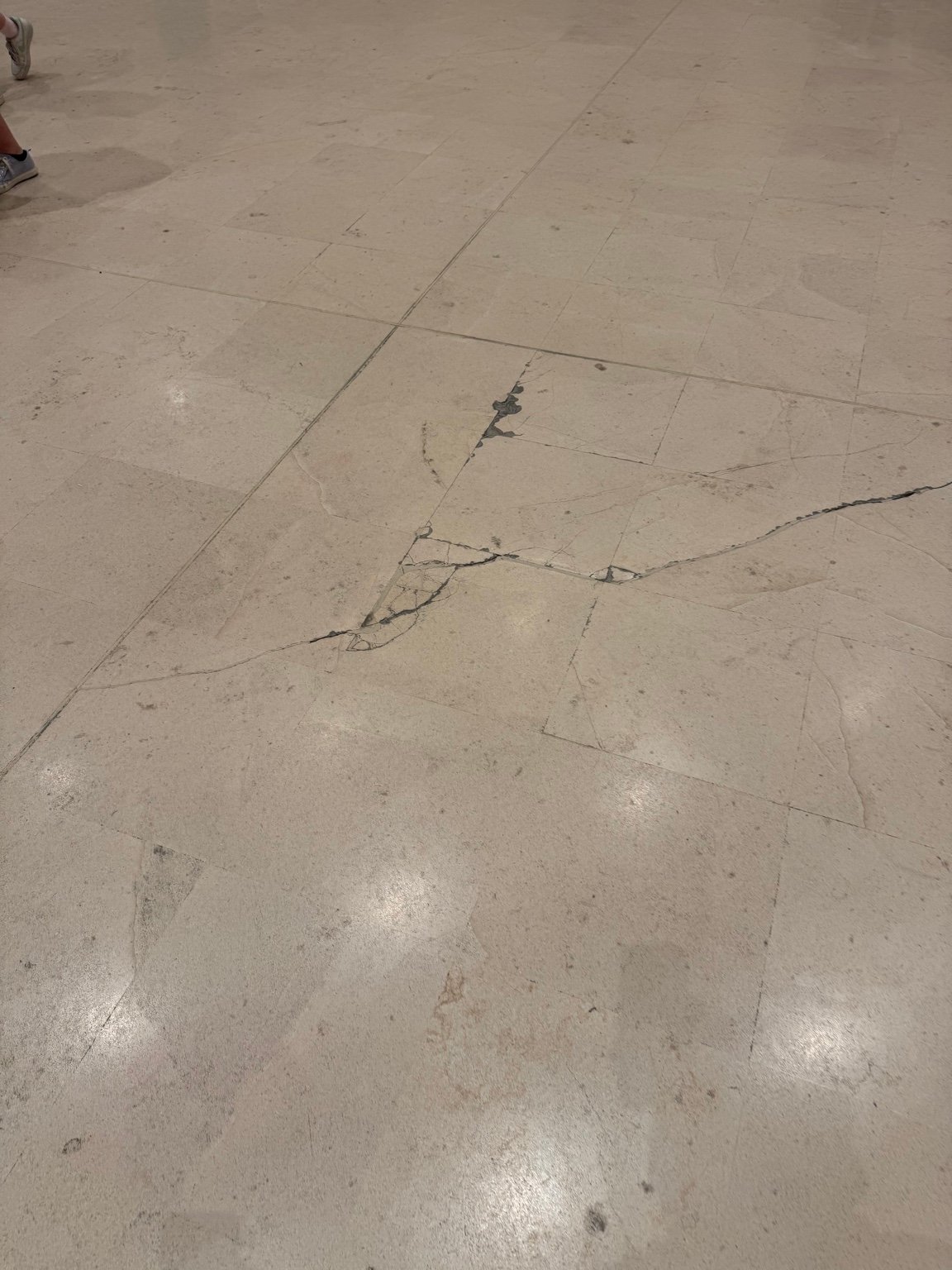 Stone floor surfaces at the Louvre showing visible wear and the need for careful maintenance.