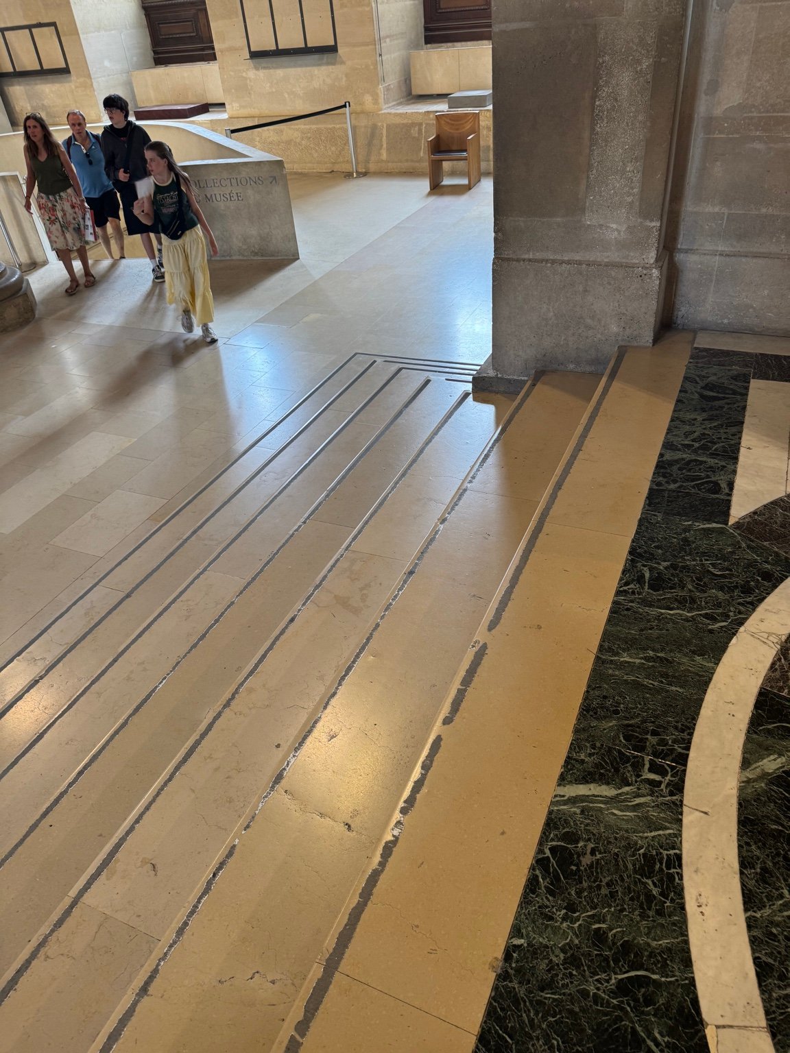 Worn stair edges and anti-slip strips inside the Louvre showing traces of heavy visitor use.