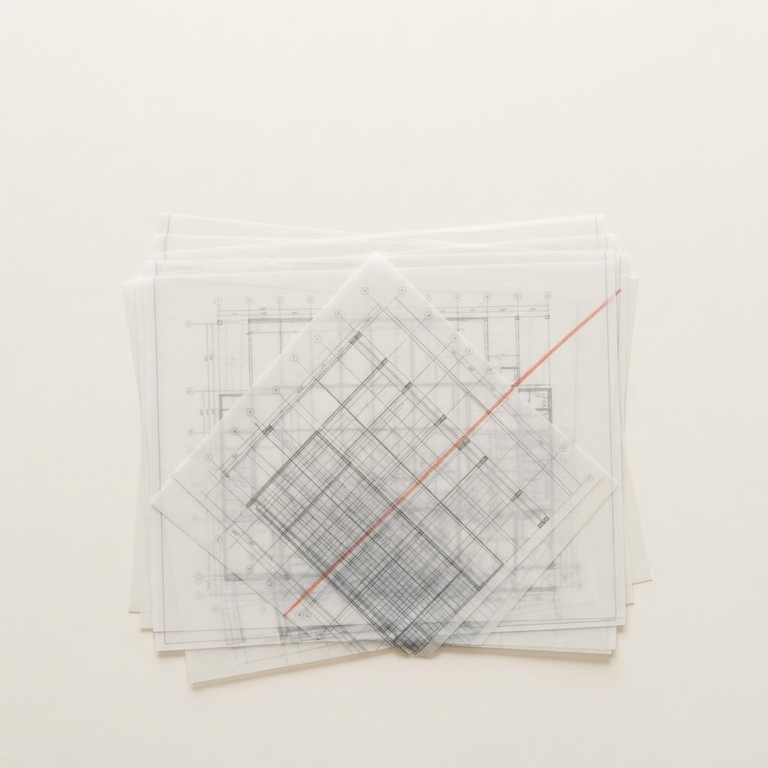Architectural drawing sheets with subtly misaligned grids symbolizing coordination failure